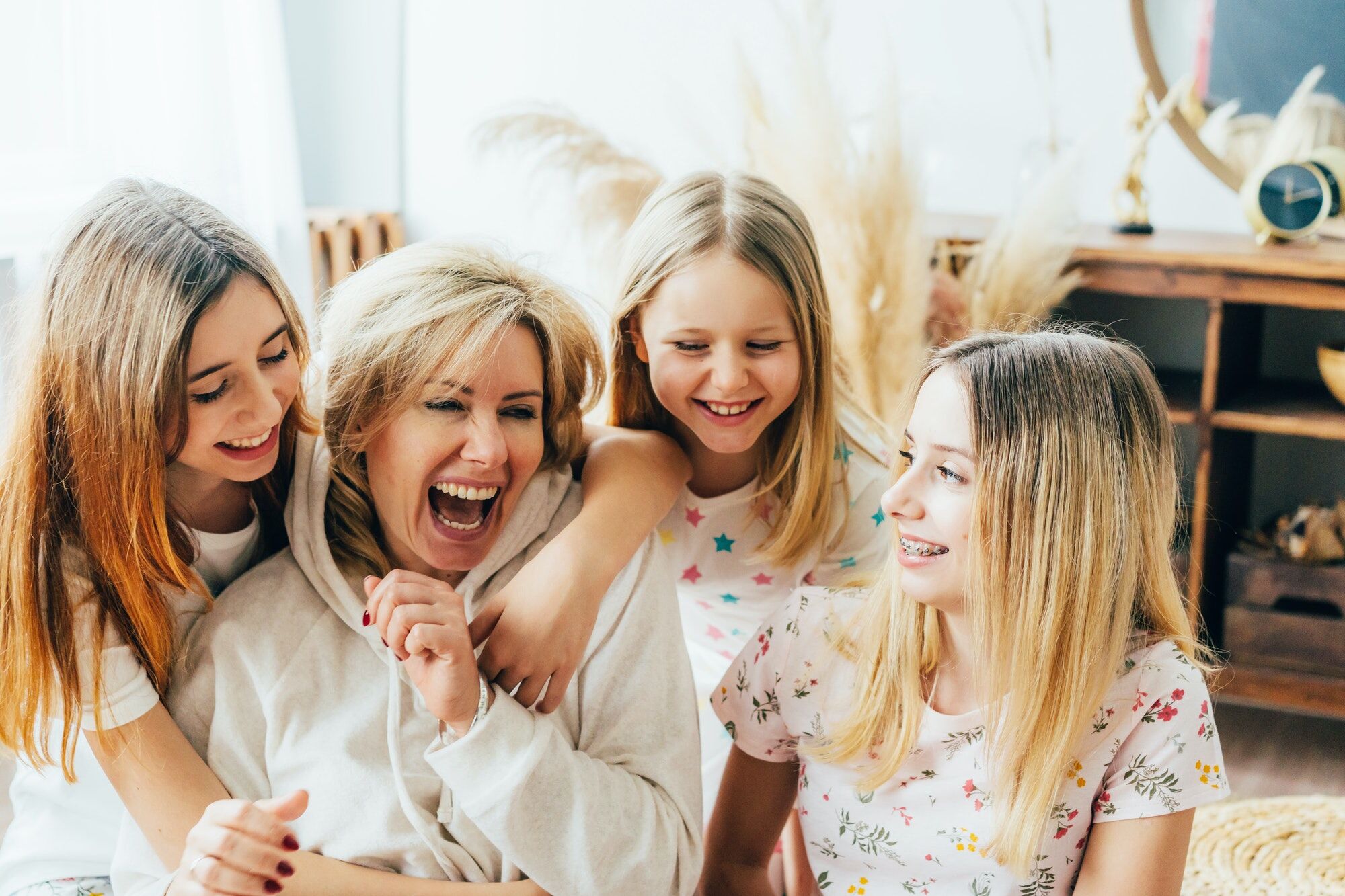 Emotional happy relationship of mom with daughters, embrace and laughter
